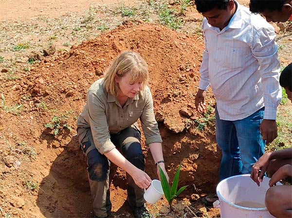 Sustainable Tourism - Tourist planting a coconut palm in South India