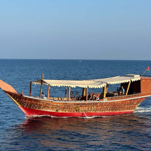 Un dhow tradizionale in legno naviga lungo le spettacolari coste del Sultanato dell'Oman