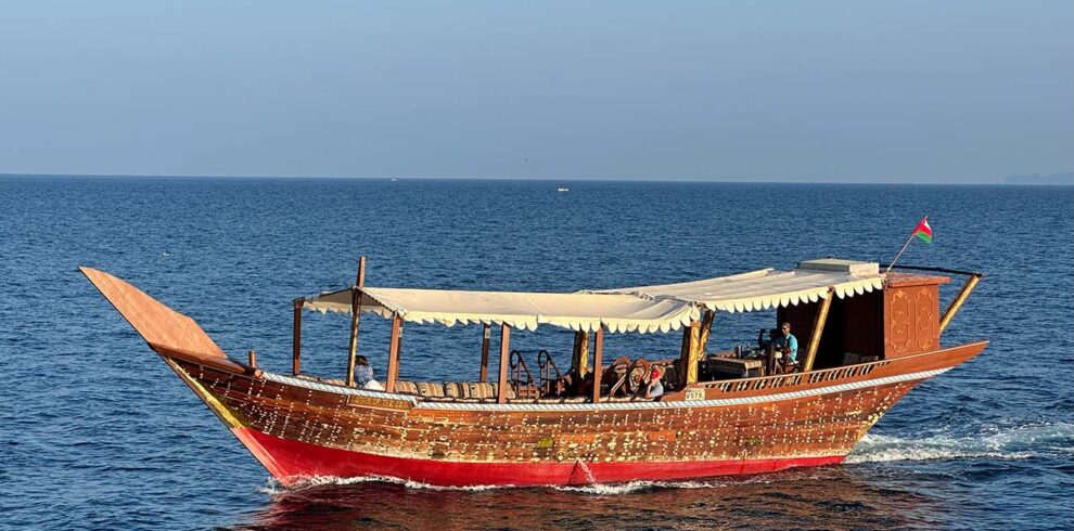 Un dhow tradizionale in legno naviga lungo le spettacolari coste del Sultanato dell'Oman