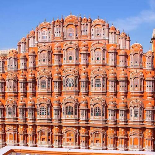 La monumentale facciata in arenaria rosa dell'Hawa Mahal, il Palazzo dei Venti, con le sue caratteristiche finestre intagliate a Jaipur, Rajasthan, India.