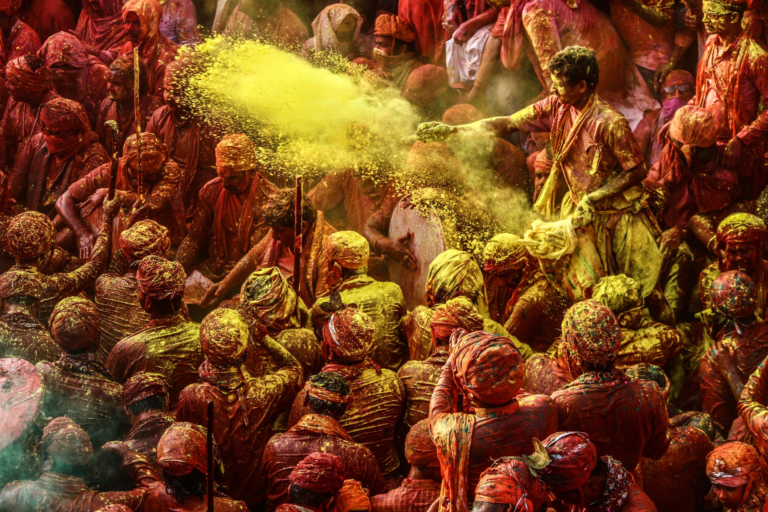 Persone festanti celebrano il festival dei colori Holi lanciando polveri colorate nell'aria durante un viaggio culturale in India.