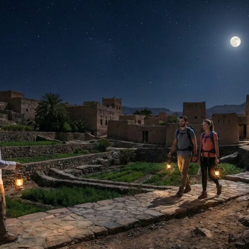 Un'escursione notturna a piedi sotto la luce della luna piena tra le antiche case in pietra e i terrazzamenti di Misfat Al Abriyeen, Oman.