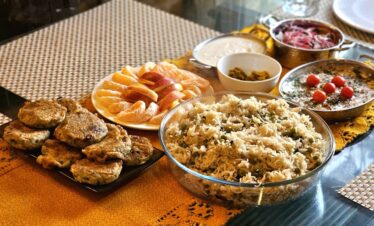 A vibrant Indian meal featuring rice and various dishes, presented beautifully on a table.