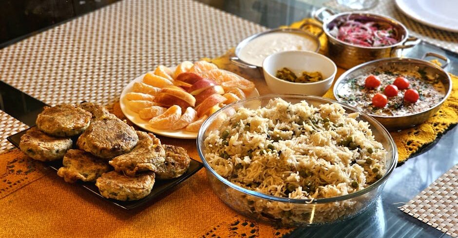 A vibrant Indian meal featuring rice and various dishes, presented beautifully on a table.