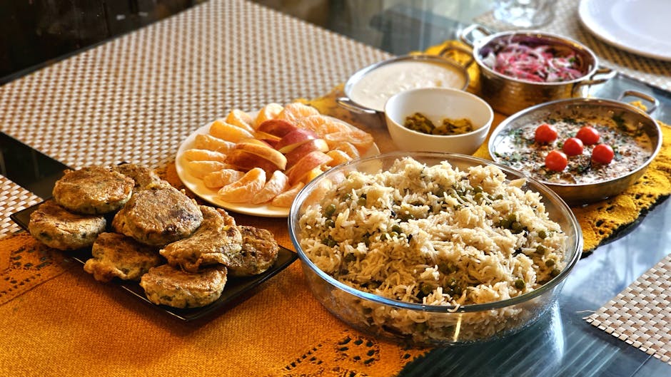 A vibrant Indian meal featuring rice and various dishes, presented beautifully on a table.
