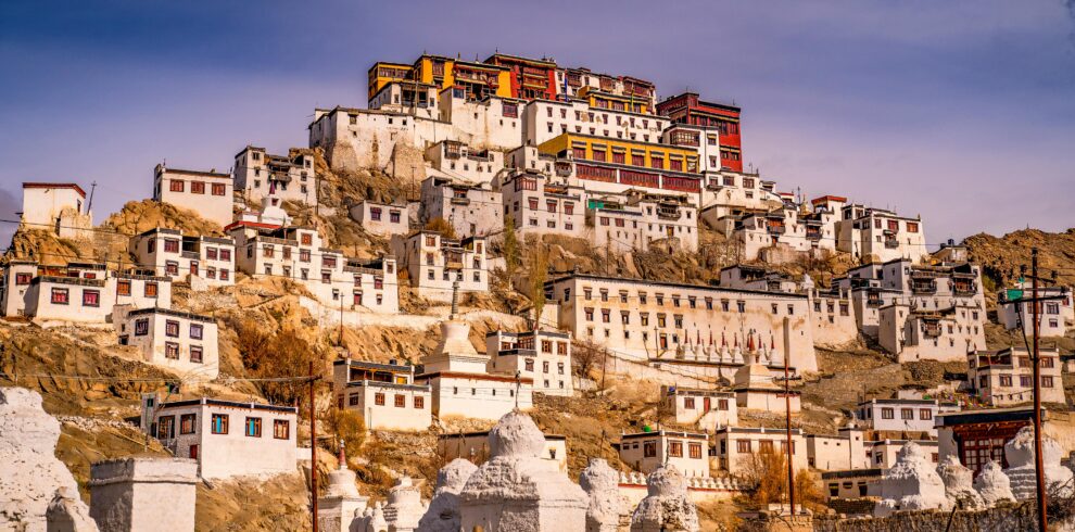 A stunning view of Thiksey Monastery against a warm sunset sky, showcasing its grandeur.